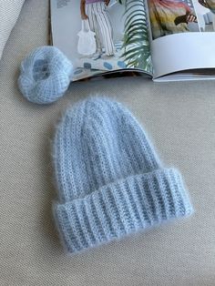 a knitted hat next to a knitting book