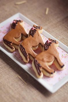 four decorated cookies sitting on top of a white plate