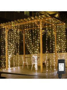 an outdoor gazebo covered in lights and string lights with chairs around it at night