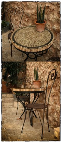 the table and chairs are made out of mosaic tiles with wrought iron arms, which also have planters on them