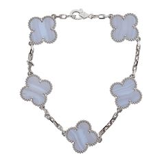 This Van Cleef & Arpels Vintage Alhambra 5 motif bracelet is in blue rhodium-plated 18K white gold and chalcedony with a lobster clasp.Origin: FranceCondition: New and never worn Accompanied by: VCA green jewelry box, authenticity card, carebook, and extra adjustable linksMeasurements: .5" x .5" motif pendant; 7" bracelet length Blue Van Cleef Bracelet, Van Cleef Alhambra, Louis Vuitton Petite Malle, Chalcedony Bracelet, Neverfull Mm Monogram, Blue Vans, Van Cleef And Arpels, Green Jewelry, Vintage Louis Vuitton