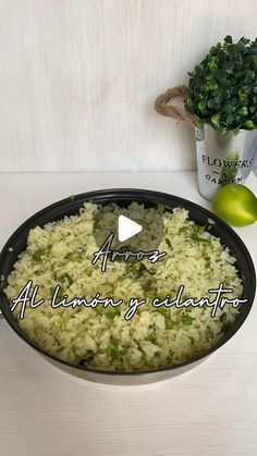 a bowl filled with rice and vegetables next to a potted plant on top of a table