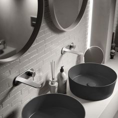 two sinks in a bathroom with mirrors and soap dispensers