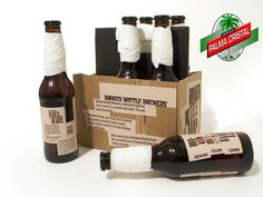 six bottles of beer sitting in front of a cardboard box with labels on the side