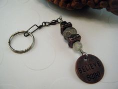 a keychain with a charm that says believe 3500 on the front and back