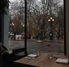 a table with two glasses and napkins on it in front of a large window