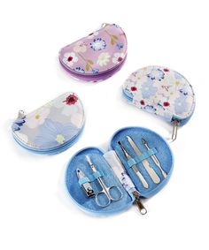 three different types of scissors and case on a white surface with floral designs, including flowers