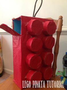 a red bag made out of toilet paper sitting on top of a wooden floor