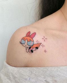 a woman's shoulder with a cartoon character tattoo on her left shoulder and an orange fox in the center