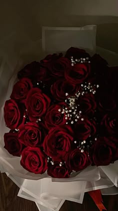 a bouquet of red roses with pearls on it