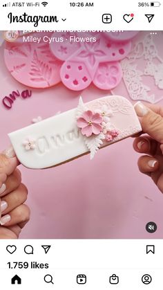 someone is holding up a pink flower on top of a white piece of paper that says congratulations