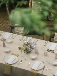 the table is set with white plates and silverware