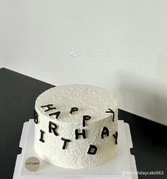 a white cake with black writing on it