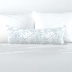 a white bed topped with pillows and blankets