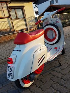 a white and red scooter parked in front of a house