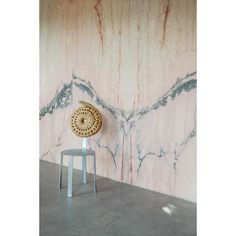 a chair sitting on top of a cement floor next to a wall covered in marble