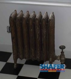 an old radiator in the corner of a room with black and white checkered flooring