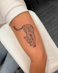 a person with a tattoo on their arm that has a cheetah on it