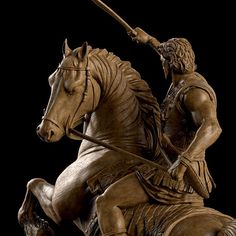 a statue of a man riding on the back of a horse with a spear in his hand