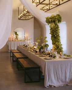 the table is set with candles, flowers and greenery for an elegant wedding reception