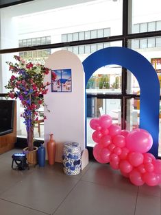 balloons and vases are on the floor in front of a window with an arch