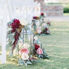 a row of white chairs sitting next to each other on top of a grass covered field