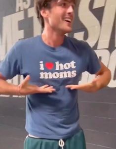 a man with his hands out in front of him and the words i love hot moms on it