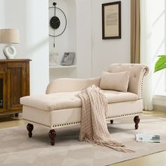 a living room with a white couch and beige rug on the floor next to a window