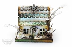 a small house made out of scrapbook pages with lots of different things on it