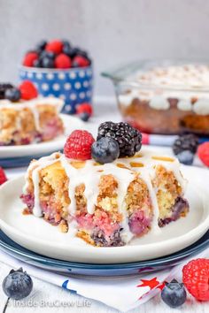 a slice of berry crumb cake on a plate with berries and blueberries around it