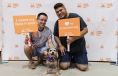 two men sitting on the ground with signs in front of them that say i saved my best friend