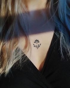 a woman's neck with a small flower tattoo on her left side ribcage