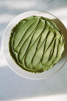 a white plate topped with green frosting on top of a table