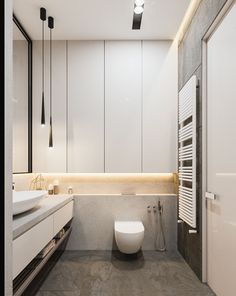 a modern bathroom with white cabinets and grey tile flooring, along with a toilet