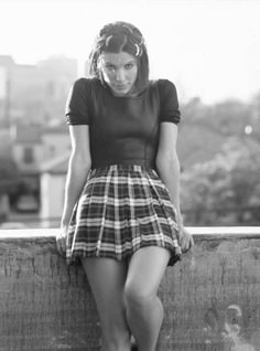 a woman sitting on top of a wooden bench