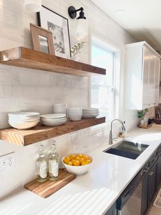 a bowl of oranges sitting on top of a kitchen counter