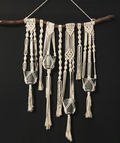 macrame hanging from a wooden stick on a black background