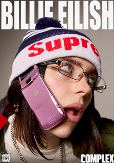 a woman wearing glasses and a knitted hat talking on a cell phone with her mouth open