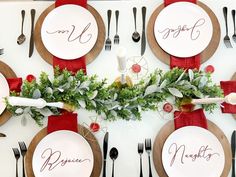 the table is set for christmas dinner with red napkins and silverware on it