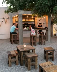 people sitting at wooden tables in an outdoor restaurant