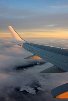 the wing of an airplane flying above clouds