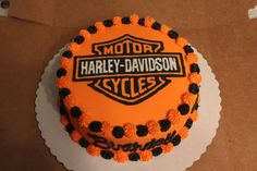 an orange and black harley davidson cake sitting on top of a table