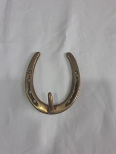 a brass colored horseshoe shaped object on a white sheet