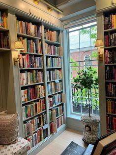 a room filled with lots of books next to a window