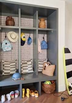 a shelf with hats and other items on it next to a wall mounted coat rack