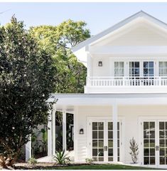 a white house with large windows and balconies