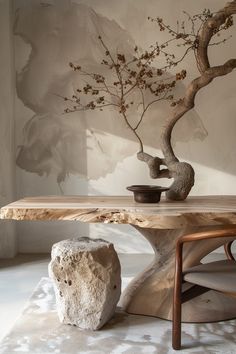 a bonsai tree in a vase next to a table with a rock on it