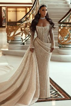 a woman in a gown and tiara standing on a carpeted floor next to stairs