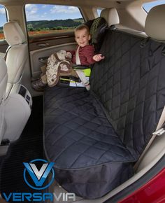 a little boy sitting in the back seat of a car with a blanket on it