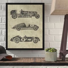 an old fashioned race car poster hanging on a wall next to a lamp and chair